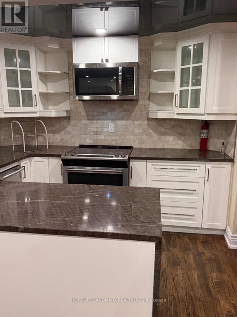 A kitchen with white cabinets and a brown countertop.