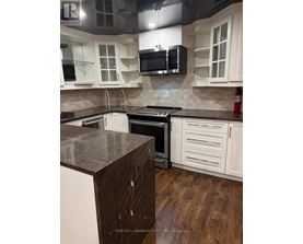 A kitchen with white cabinets and a wooden island.