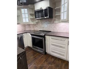 A kitchen with a black microwave above the stove.