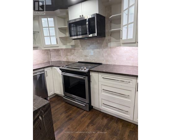 A kitchen with a black microwave above the stove.