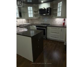 A kitchen with a black counter top and white cabinets.