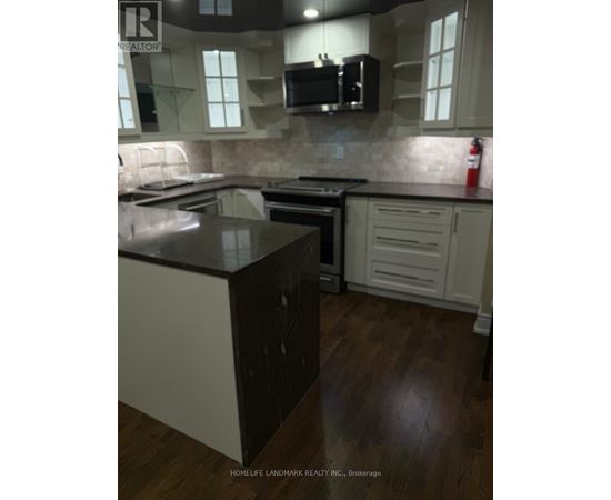 A kitchen with a black counter top and white cabinets.