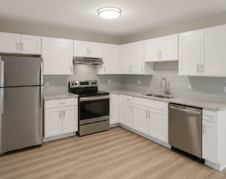 A kitchen with white cabinets and stainless steel appliances.