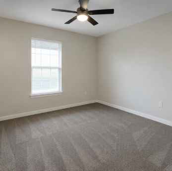 A room with a ceiling fan and a window.