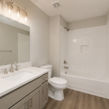 A white toilet sits next to a sink in a bathroom.