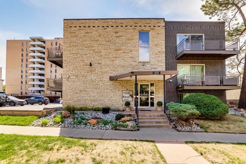 A modern house with a stone facade and a balcony on the second floor.