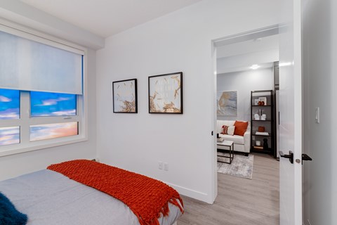 A bedroom with a bed and a window with a view of the sky.