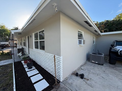 A white house with a black and white striped walkway in front.