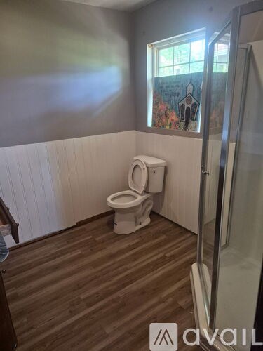 A bathroom with a toilet and a window.