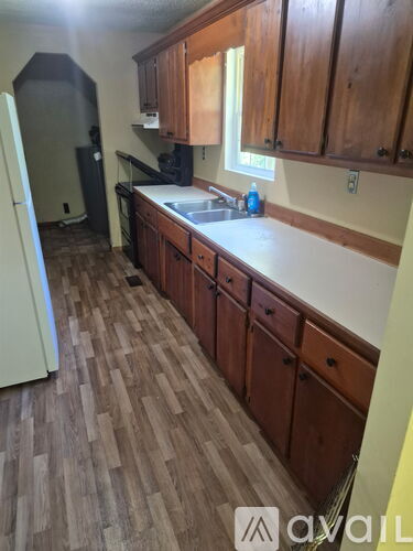 A kitchen with wooden floors and cabinets.