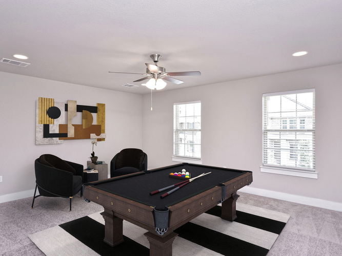 A pool table is in the middle of a room with two chairs and a painting on the wall.