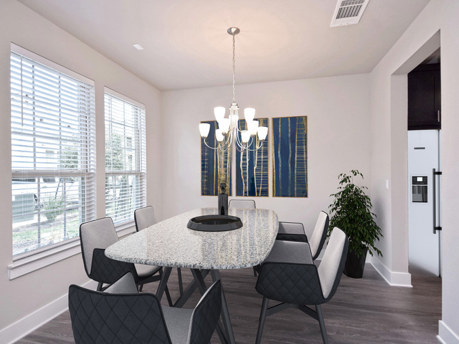 A dining room with a round table and chairs.