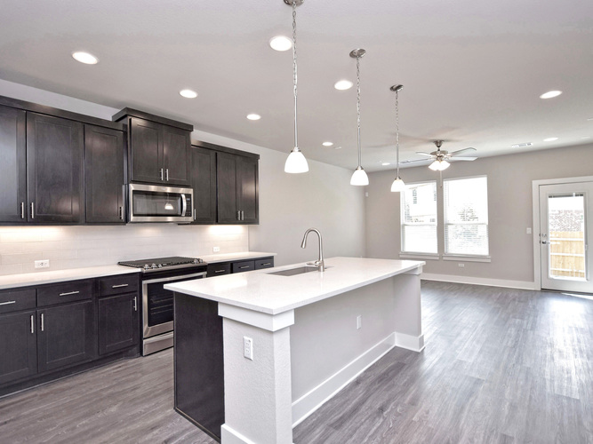 A modern kitchen with dark wood cabinets and a white island.