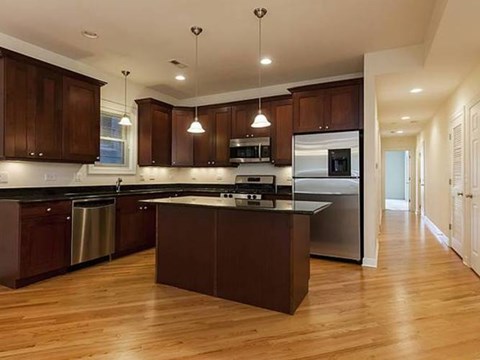 A kitchen with dark wood cabinets and stainless steel appliances.