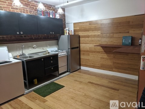 A kitchen with a refrigerator, sink, and cabinets.