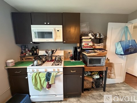 A kitchen with a white stove and a white oven with a green stove top.