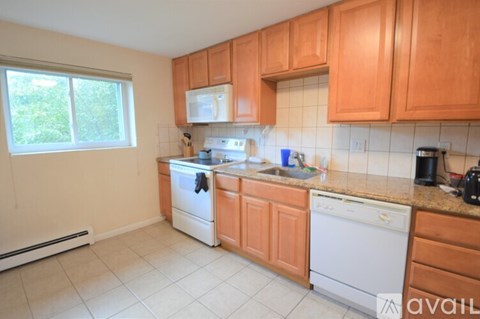 A kitchen with wooden cabinets and white appliances.