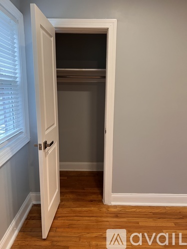 A white door is open to a dark room.