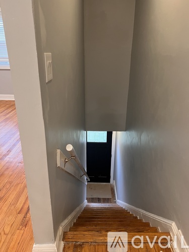 A staircase with wooden steps and a white handrail.