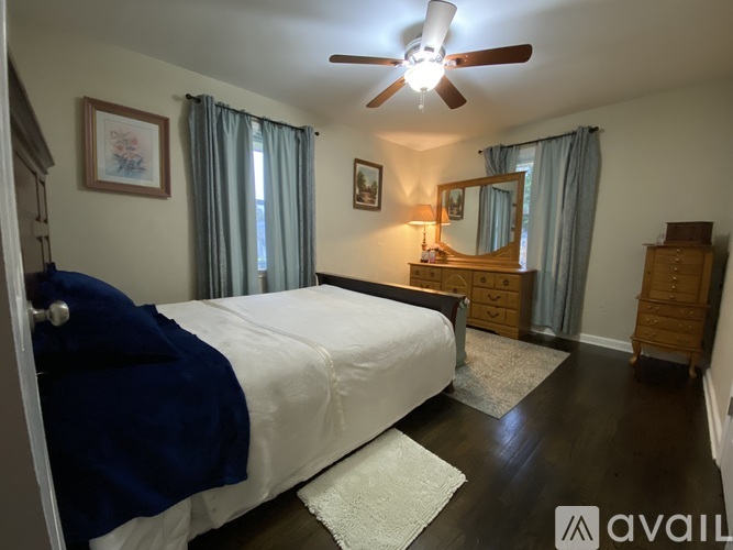 A bedroom with a bed, dresser, and mirror.
