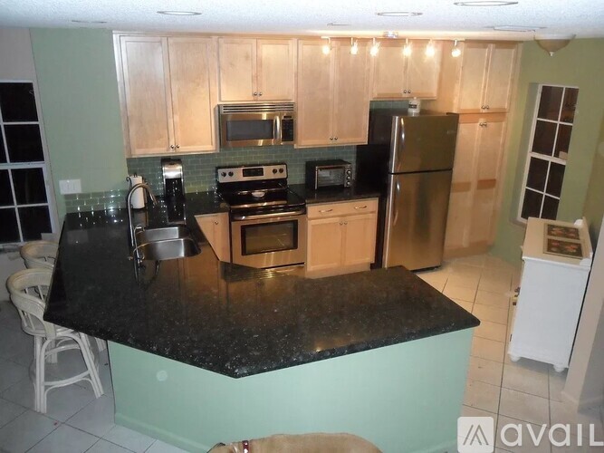 A kitchen with a black countertop and stove.