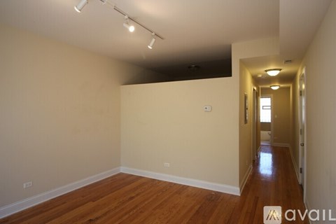 A long hallway with wooden floors and white walls.