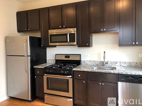 A kitchen with dark brown cabinets and stainless steel appliances.