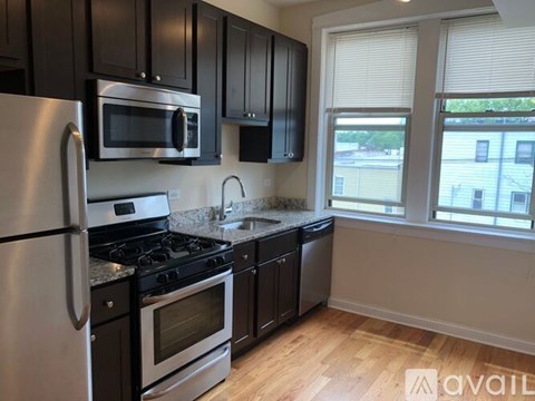 A kitchen with black cabinets and stainless steel appliances.