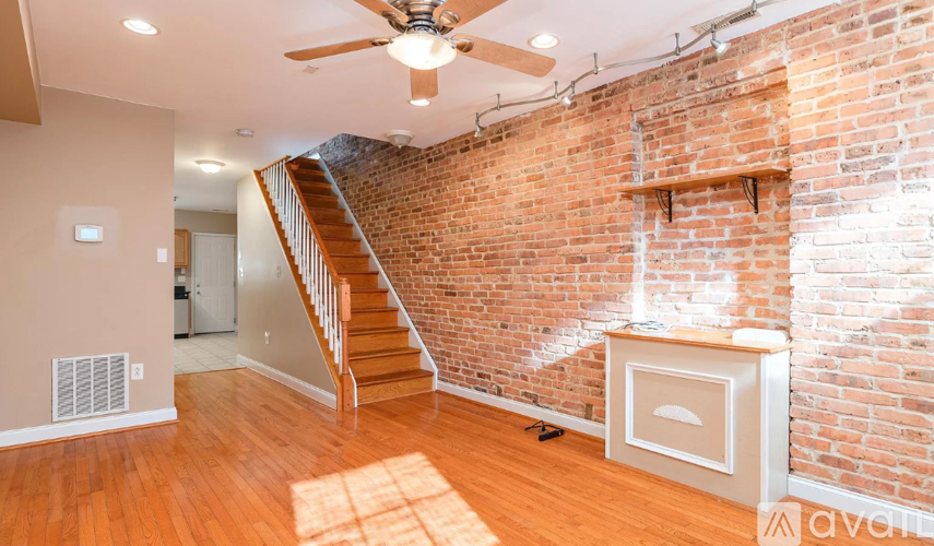 A room with a brick wall and wooden floors.