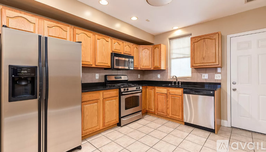 A kitchen with wooden cabinets and a stainless steel refrigerator.