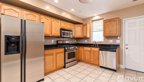 A kitchen with wooden cabinets and a stainless steel refrigerator.