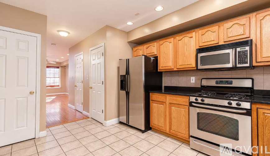 A kitchen with wooden cabinets and black appliances.