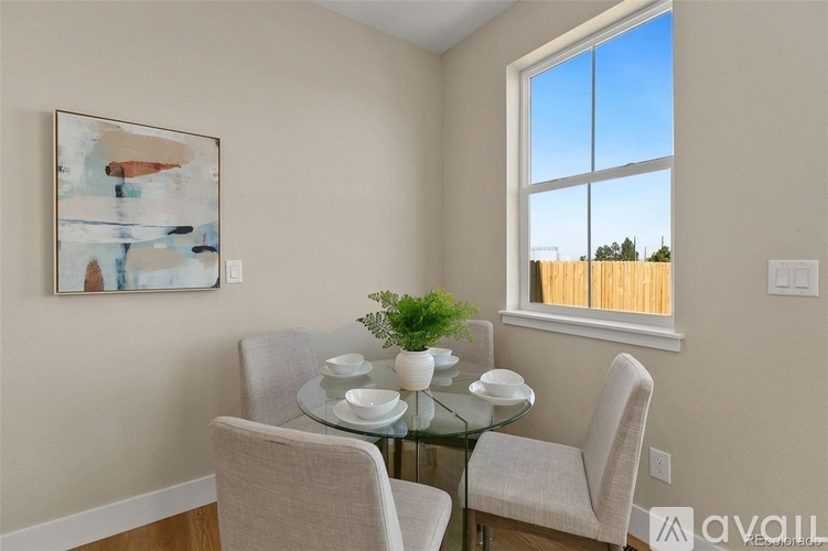 A dining room with a glass table and two chairs.