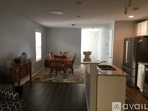 A kitchen with a dining table and chairs in the middle of the room.