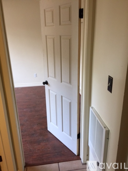 A white door is in a room with a brown floor.
