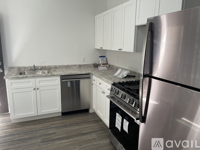 A kitchen with a stainless steel refrigerator, oven, and cabinets.