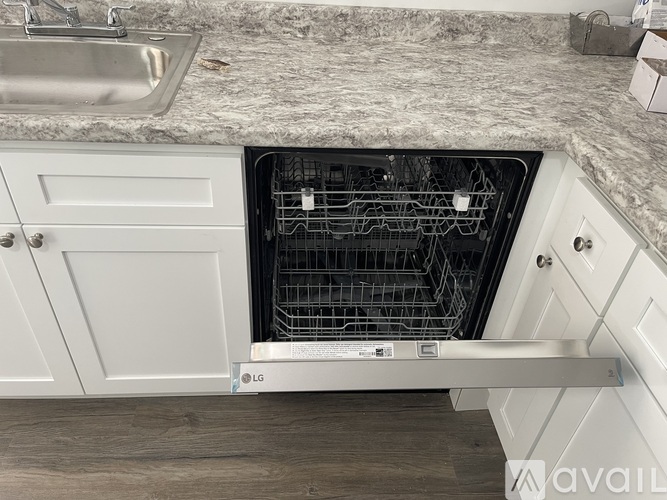 A white LG dishwasher is open in a kitchen.