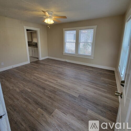 A room with wooden flooring and a ceiling fan.