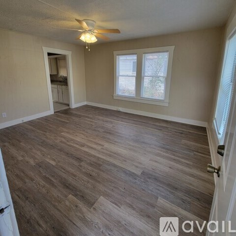 A room with wooden flooring and a ceiling fan.