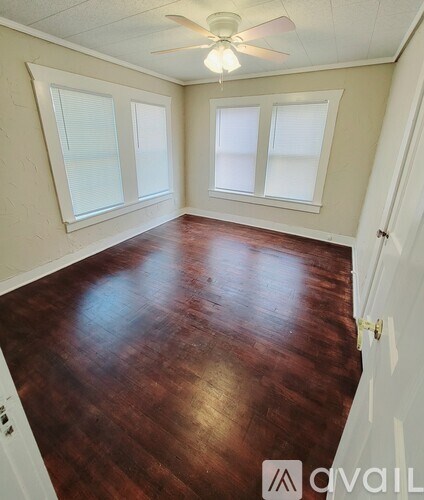 A room with wooden flooring and a ceiling fan.