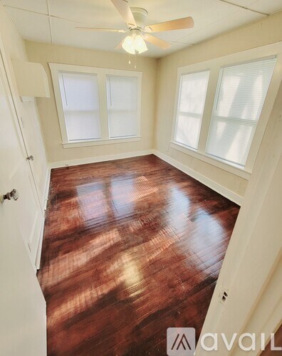 A room with a wooden floor and a ceiling fan.