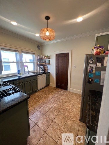 A kitchen with a black stove top and a black fridge.