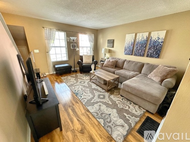 A living room with a couch, chair, and television.