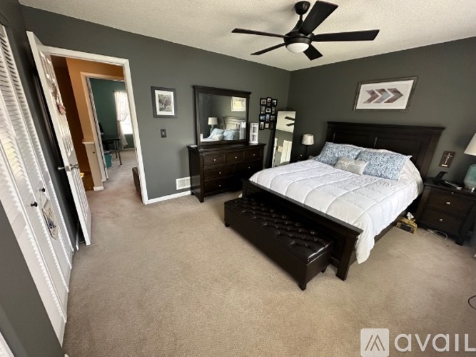 A bedroom with a bed, dresser, and mirror.