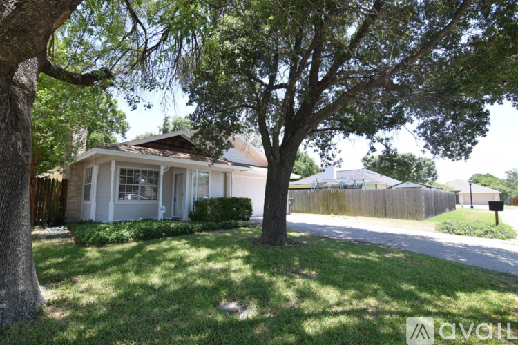 A tree in front of a house with a sign that says "available".