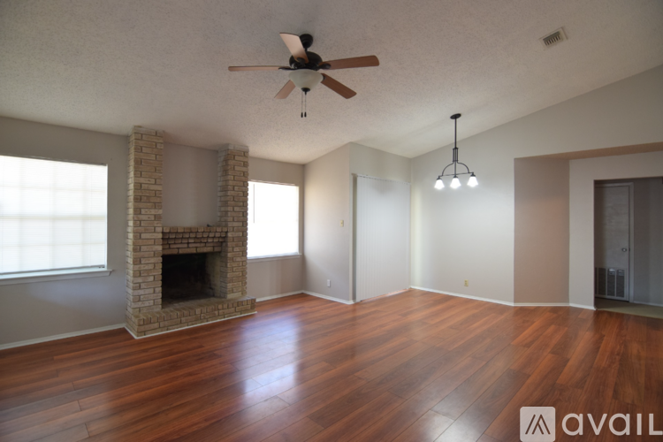 A living room with a fireplace and wood flooring.