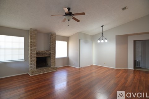 A living room with a fireplace and wood flooring.