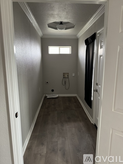 A hallway with a light on the ceiling and a door on the right.