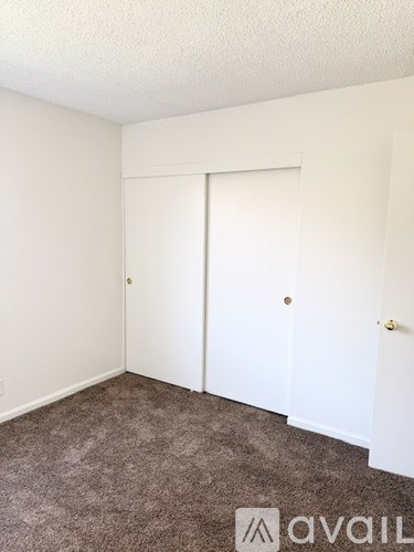 A room with a carpeted floor and a white door.
