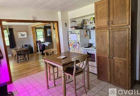 A kitchen with wooden cabinets and a table with chairs.